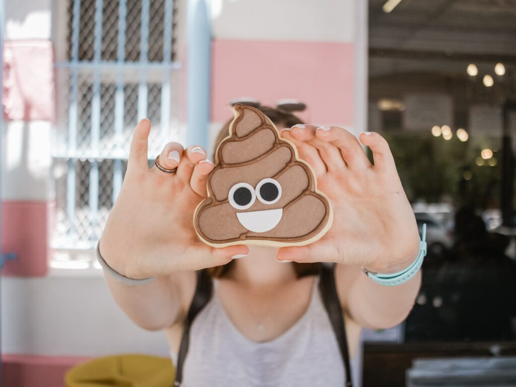 hands holding a smiling poop emoji